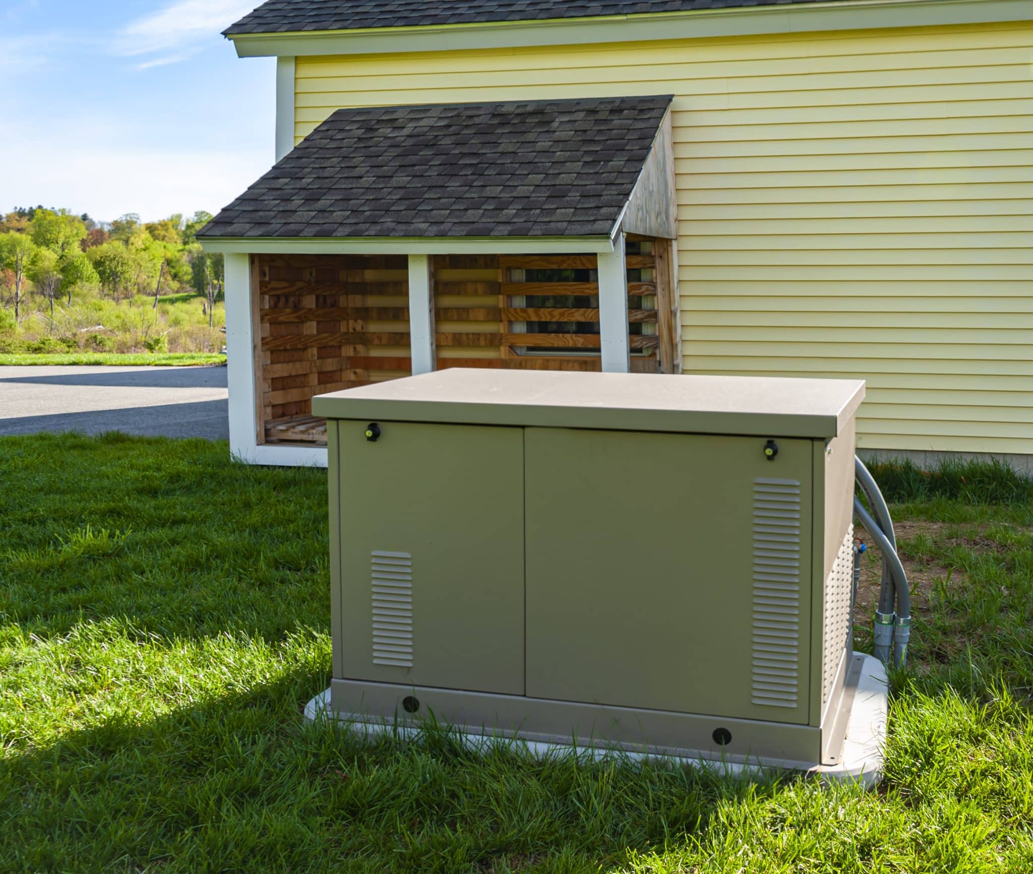 A home backup generator installed on a concrete pad outside a home.
